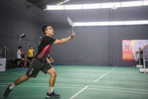 A man holding a tennis racquet on top of a tennis court