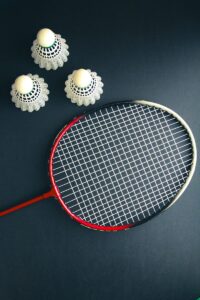 A tennis racket and four balls on a table