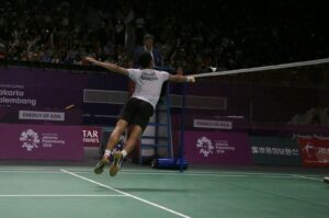 man in white t-shirt and black shorts playing tennis