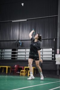 A woman playing badminton indoors