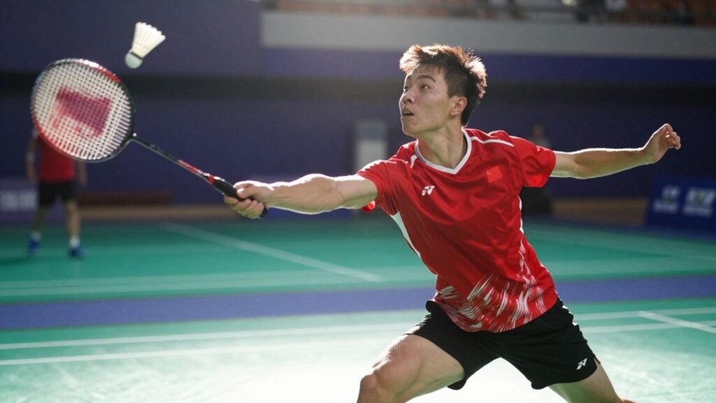 Badminton player smashing shuttlecock in mid-air.